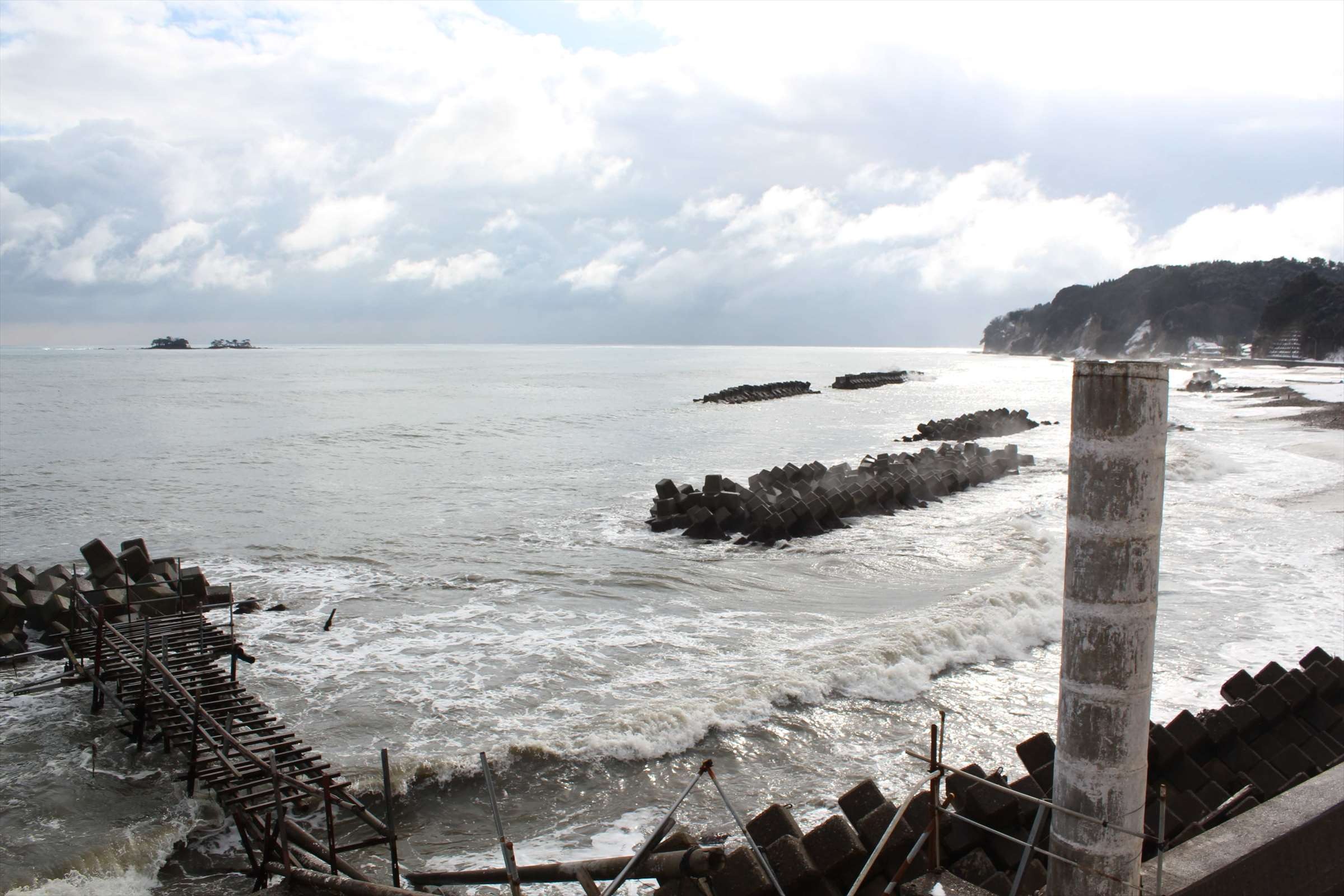 冬の荒れた海とテトラポッド、富山湾の波しぶき