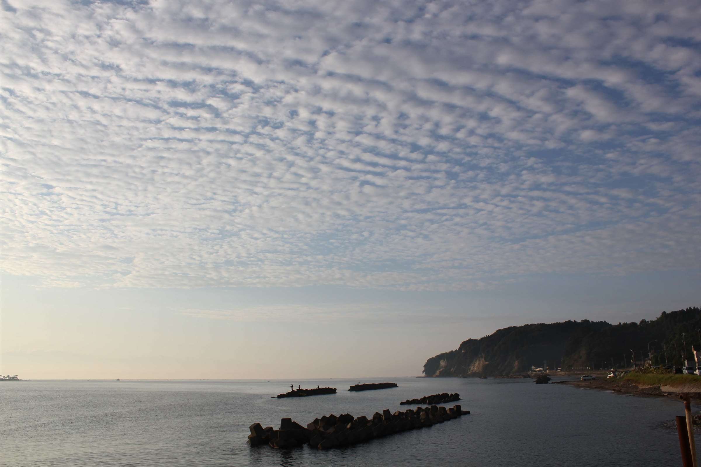 うろこ雲が広がる朝の空と富山湾の海岸