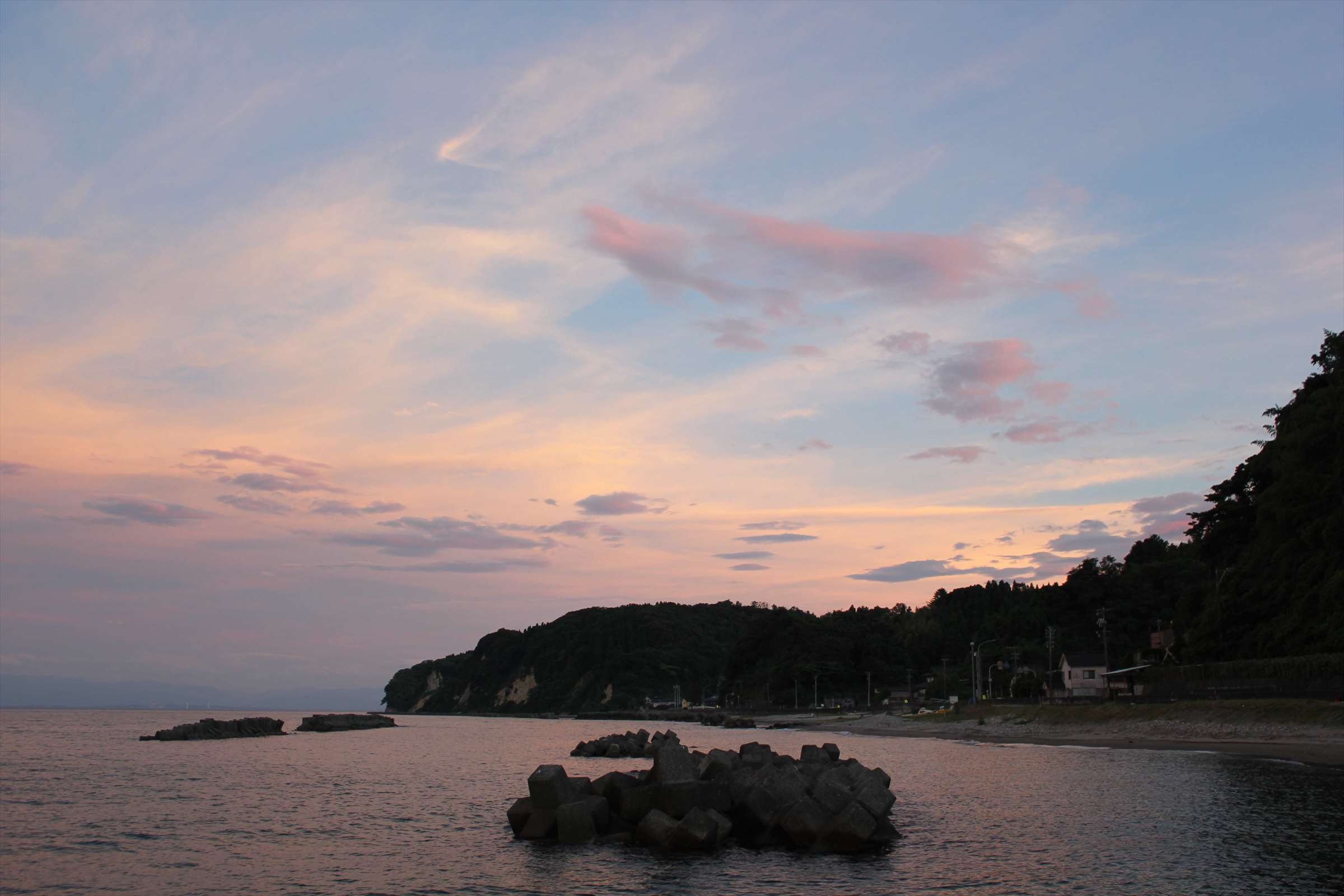 ピンクに染まった夕暮れの空と富山湾の海岸