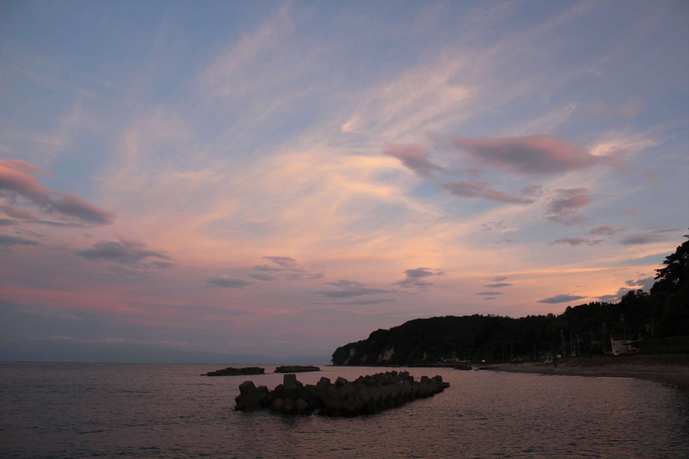 淡いピンクの夕空と防波堤、富山湾の海岸