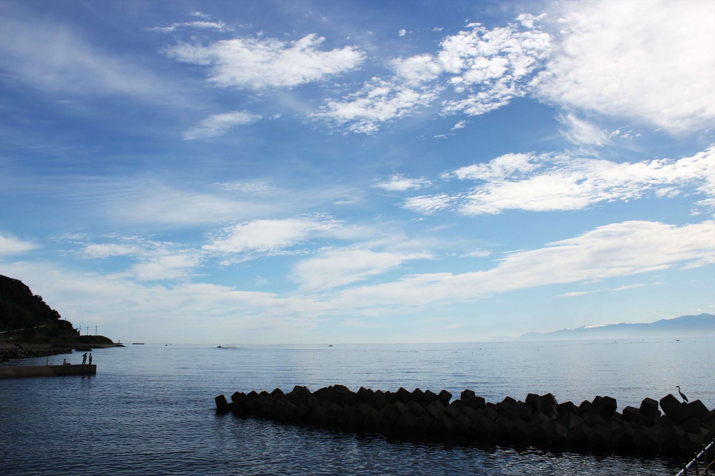 青空と白い雲、テトラポッドが並ぶ夏の富山湾