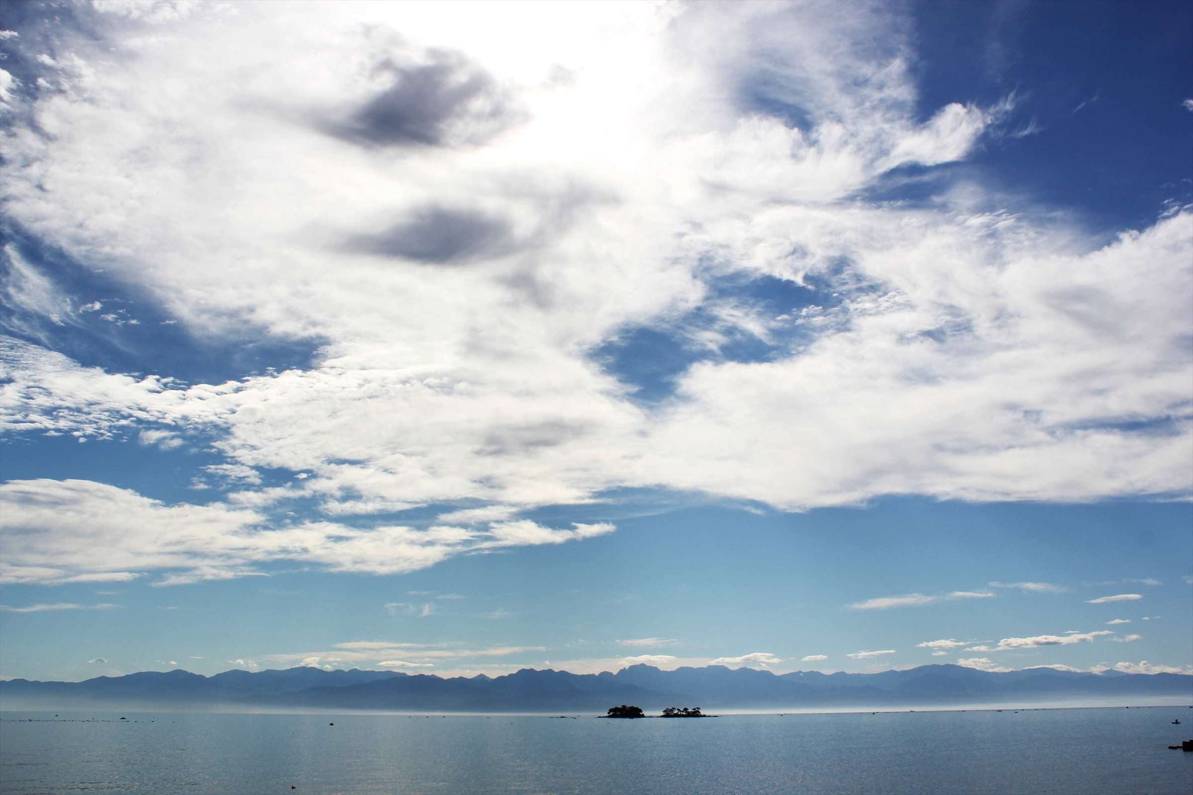 青空と雲が広がる夏の富山湾と立山連峰